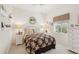 Cozy bedroom featuring a floral-patterned bedspread, white nightstands, and a window view at 1251 Tuscany Blvd, Venice, FL 34292