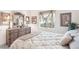 Bright bedroom featuring a light floral comforter and a large wood dresser with decorative mirror at 1251 Tuscany Blvd, Venice, FL 34292