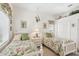 Bedroom featuring two twin beds with floral bedding, parrot decor, and white walls at 1251 Tuscany Blvd, Venice, FL 34292