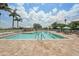 Community swimming pool with lounge chairs, umbrellas, and a tiled deck on a sunny day at 1251 Tuscany Blvd, Venice, FL 34292