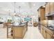 Open concept kitchen with island, stainless appliances and seamless flow to the living and dining areas at 1251 Tuscany Blvd, Venice, FL 34292