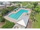 Aerial shot of the community pool featuring a lap area, sun loungers, umbrellas, and lush landscaping at 1251 Tuscany Blvd, Venice, FL 34292