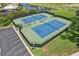 Aerial view of tennis courts with professional surface, manicured landscaping, and a nearby parking area at 1251 Tuscany Blvd, Venice, FL 34292