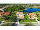 Aerial view of a yellow stucco home with terra cotta tile roof located on a pond, surrounded by mature landscaping at 12520 Natureview Cir, Bradenton, FL 34212
