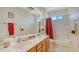 Bright bathroom featuring a double vanity, large mirror, and shower-tub combination at 12520 Natureview Cir, Bradenton, FL 34212