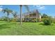 Expansive backyard with tall palm trees, manicured lawn, an enclosed pool, and a glimpse of the home's facade at 12520 Natureview Cir, Bradenton, FL 34212