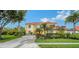 Beautiful yellow two-story home with a tile roof, well-maintained landscaping, and a long driveway at 12520 Natureview Cir, Bradenton, FL 34212
