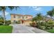Exterior view of a yellow two-story home with a tile roof and mature, manicured landscaping at 12520 Natureview Cir, Bradenton, FL 34212