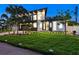 Elegant modern home with dark accents, manicured lawn, landscape lighting, and lush tropical landscaping at 1323 Loma Linda Ct, Sarasota, FL 34239