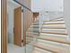 Elegant staircase with glass railing, wood accents, and ambient lighting for a sleek design at 1323 Loma Linda Ct, Sarasota, FL 34239