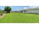 Lush green backyard featuring a well-maintained lawn, privacy fence, and manicured landscaping around the house at 1334 De Prie Rd, Englewood, FL 34223