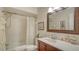 Bathroom with bath-shower combo, vanity with hard surface countertop, and decorative mirror at 1334 De Prie Rd, Englewood, FL 34223
