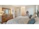 Bedroom with wooden dresser, plush bed with decorative pillows and ensuite access to closets and bath at 1334 De Prie Rd, Englewood, FL 34223