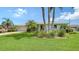 Beautiful single-story home with lush green lawn, palm trees, and well-maintained landscaping at 1334 De Prie Rd, Englewood, FL 34223