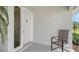 Cozy front porch with neutral-colored walls, a white front door, and outdoor seating at 1334 De Prie Rd, Englewood, FL 34223