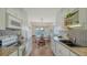 Galley kitchen showcasing white cabinets, modern appliances, and an adjacent dining area at 1334 De Prie Rd, Englewood, FL 34223