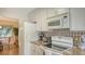 Bright kitchen with white cabinets, granite counters, and stainless steel appliances at 1334 De Prie Rd, Englewood, FL 34223