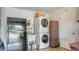 Functional laundry area with stacked washer and dryer, utility sink, and storage cabinet for convenience at 1334 De Prie Rd, Englewood, FL 34223