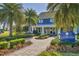 Beautiful two-story blue home with white trim, lush landscaping, and inviting walkway to The Gathering Place at 13549 Old Creek Ct, Parrish, FL 34219