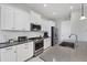 Modern kitchen with stainless steel appliances, white cabinets, and gray countertops at 13549 Old Creek Ct, Parrish, FL 34219
