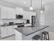 Well-lit kitchen with modern appliances, gray countertops and an island with barstool seating at 13549 Old Creek Ct, Parrish, FL 34219
