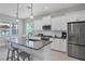 Modern kitchen features white cabinetry, stainless steel appliances, and an island with seating at 13549 Old Creek Ct, Parrish, FL 34219