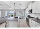 Open concept kitchen with stainless appliances, white cabinets, and a view to the living room and dining area at 13549 Old Creek Ct, Parrish, FL 34219