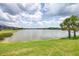 Picturesque lake view with lush green grass, beautiful palm trees, and scenic waterfront living at 13549 Old Creek Ct, Parrish, FL 34219