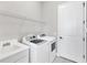 The functional laundry room features modern washer and dryer, utility sink, and ample storage shelving at 13549 Old Creek Ct, Parrish, FL 34219