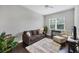 Cozy living room with comfortable seating, plush rug, and abundant natural light from the large window at 13549 Old Creek Ct, Parrish, FL 34219