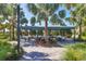 Outdoor dining area with shaded seating, lush landscaping, and a relaxing atmosphere for residents at 13549 Old Creek Ct, Parrish, FL 34219