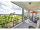Relax on the screened-in patio with serene lake views, lush landscaping, and comfortable outdoor seating at 13549 Old Creek Ct, Parrish, FL 34219