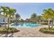 Beautiful community pool surrounded by tropical palm trees and ample lounge seating at 13549 Old Creek Ct, Parrish, FL 34219