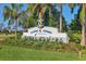 Community entrance sign for Canoe Creek surrounded by lush landscaping and mature palm trees at 13549 Old Creek Ct, Parrish, FL 34219