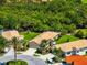 Aerial view showcasing the home's layout and surroundings, nestled among lush greenery and manicured lawns at 138 Tiziano Way, North Venice, FL 34275