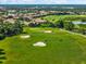Aerial view of a golf course with lush green fairways, sand traps, and residential homes in the background at 138 Tiziano Way, North Venice, FL 34275