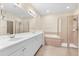 Bright bathroom boasts double sinks, a soaking tub, and a glass-enclosed shower for a spa-like experience at 138 Tiziano Way, North Venice, FL 34275
