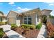 View of the home's front, showing manicured landscaping, charming walkway, and tile roof at 138 Tiziano Way, North Venice, FL 34275