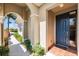 Inviting covered front porch featuring a stylish blue entry door and well-maintained landscaping at 138 Tiziano Way, North Venice, FL 34275