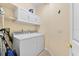 Well-equipped laundry area with ample cabinet storage and modern washer and dryer units at 138 Tiziano Way, North Venice, FL 34275