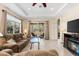 Comfortable living room with tile floors, coffered ceiling, and sliding doors offering backyard views at 138 Tiziano Way, North Venice, FL 34275
