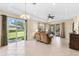 Bright and airy living room featuring tile flooring, tray ceiling, and sliding door access to the lanai at 138 Tiziano Way, North Venice, FL 34275