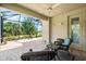 Screened-in patio featuring brick flooring, comfortable wicker furniture, and views of the lush landscape at 138 Tiziano Way, North Venice, FL 34275
