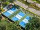 Aerial view of well maintained community pickleball courts with lush landscaping and neighborhood views at 138 Tiziano Way, North Venice, FL 34275