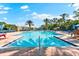 Large swimming pool with lounge chairs and palm trees in a resort-style setting for relaxation and recreation at 138 Tiziano Way, North Venice, FL 34275