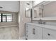 Bathroom showcasing a single sink vanity, decorative mirror, and a view into the adjacent bedroom at 1409 57Th W St # 1409, Bradenton, FL 34209