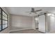 Neutral bedroom with gray floors, large windows, a ceiling fan and a barn door to the Primary bath at 1409 57Th W St # 1409, Bradenton, FL 34209