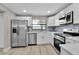 Updated kitchen with stainless steel appliances, white cabinets, and modern tile backsplash at 1409 57Th W St # 1409, Bradenton, FL 34209