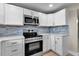 Modern kitchen with stainless steel appliances, white cabinets, sleek countertops, and stylish backsplash at 1409 57Th W St # 1409, Bradenton, FL 34209
