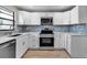 Modern kitchen featuring sleek white cabinets, stainless steel appliances, and stylish backsplash at 1409 57Th W St # 1409, Bradenton, FL 34209